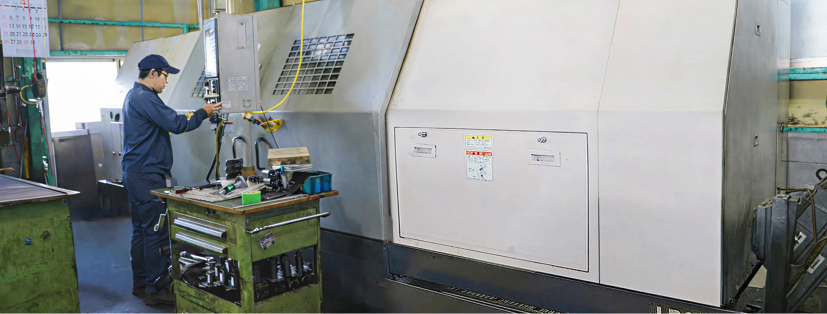 工場内で工作機械を操作する作業者