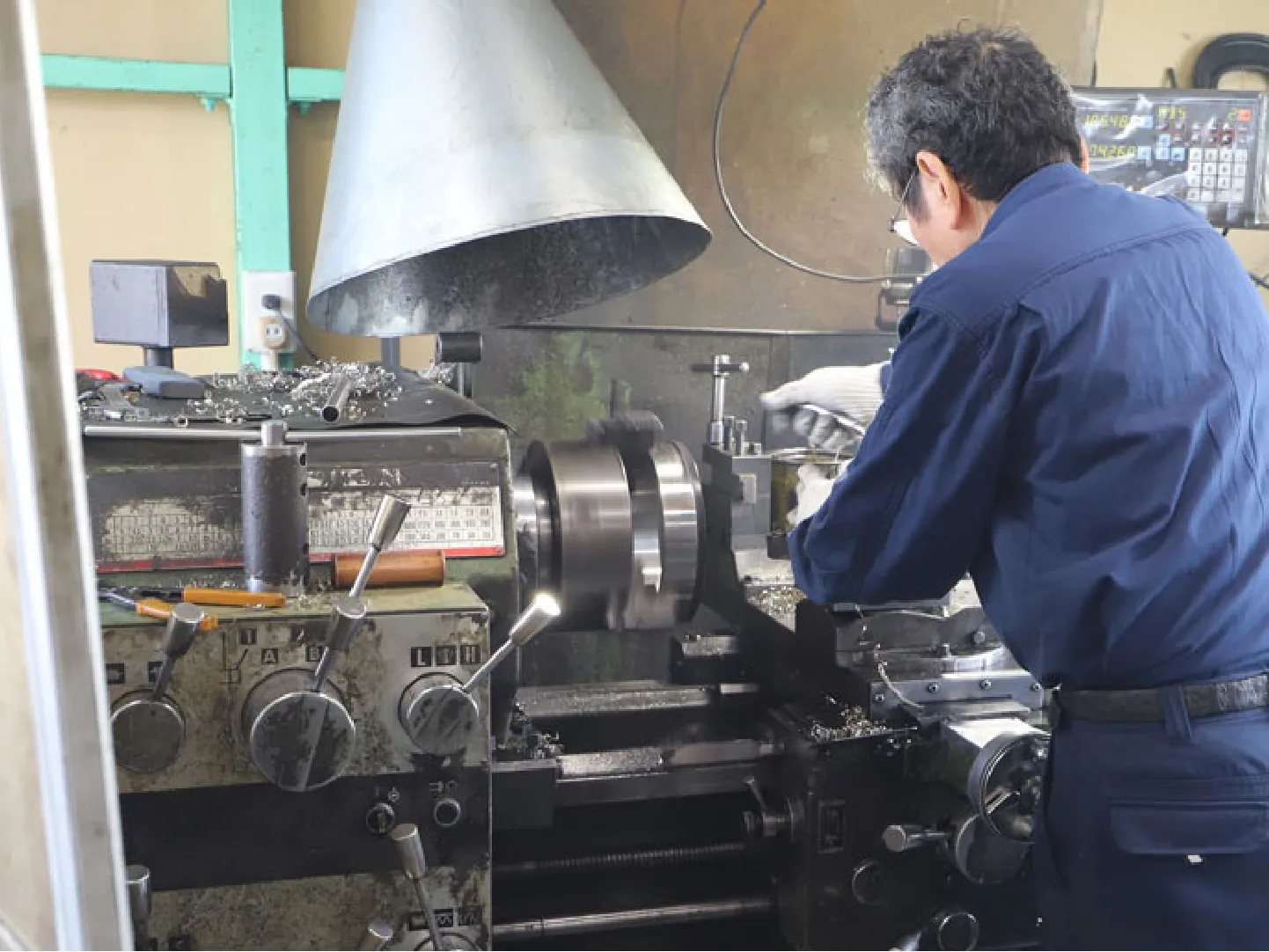 汎用旋盤でモータ部品を加工する職人