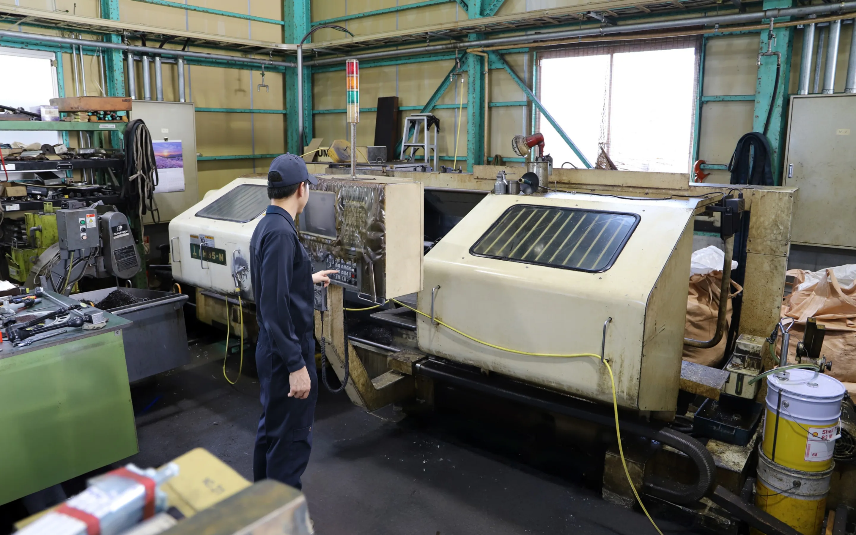 工場でNC旋盤を操作する作業者
