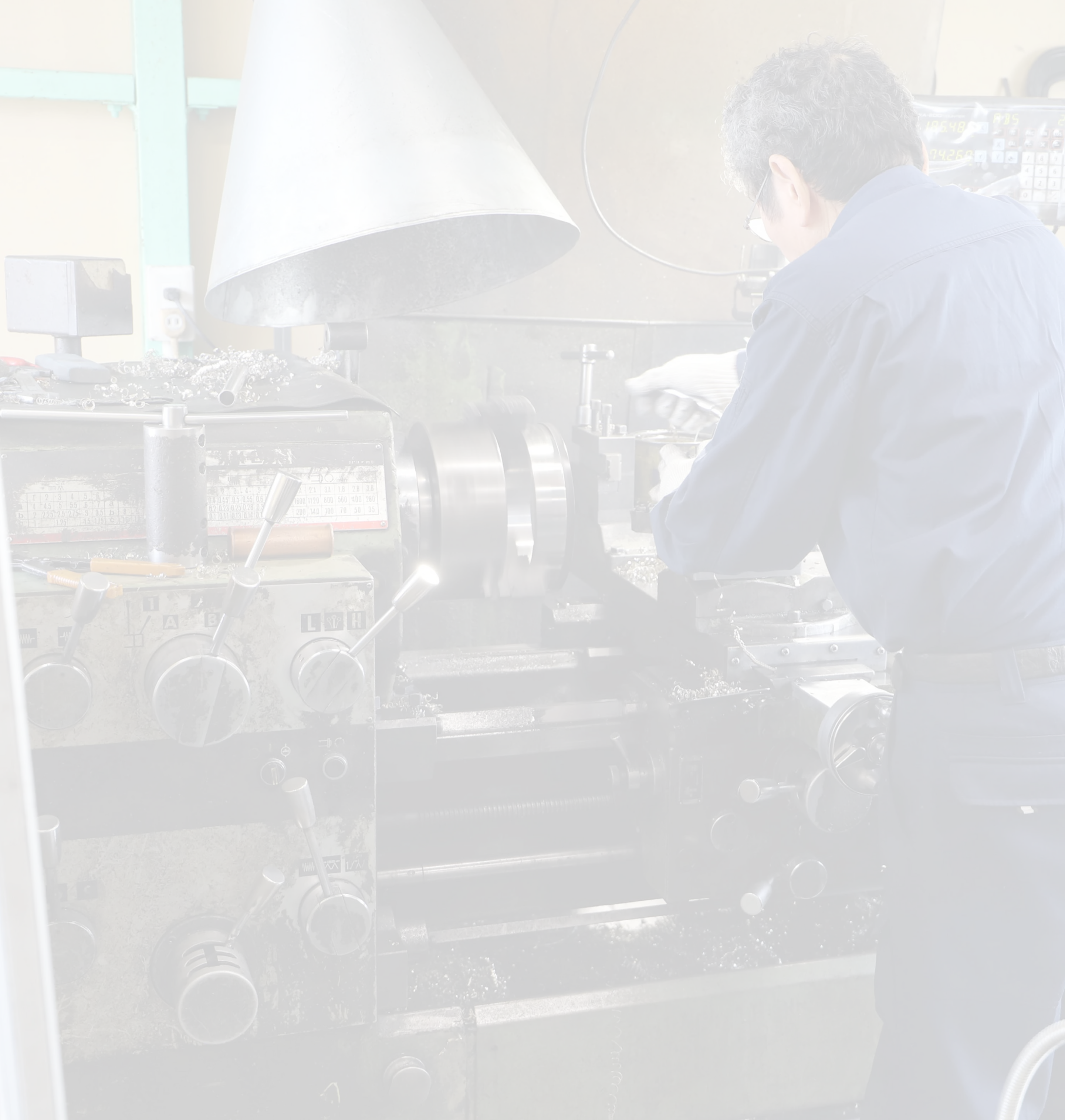 汎用旋盤で金属部品を加工する職人